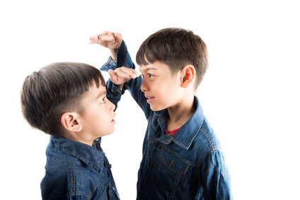 Little sibling boy brothers checking there tall each other